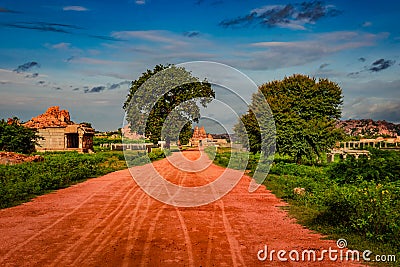 Vithala temple with leading red soil road and amazing blue sky at hampi ruins Stock Photo