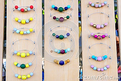 Vivid colored different types of wooden painted beads, displayed for sale at an weekend deco fair for handmade artisans, yellow, b Stock Photo