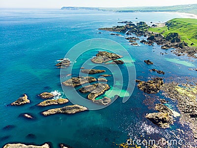 Vivid emerald-green water at Ballintoy harbour along the Causeway Coast in County Antrim Stock Photo