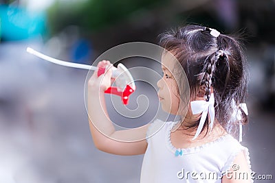 Vividness of cute girl braids play with accessories for water bottles. Stock Photo