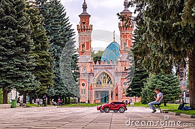 Vladikavkaz, Russia - 07 18 2019: Young businessman with a few kids electric cars waiting for a client in front of Sunni Editorial Stock Photo