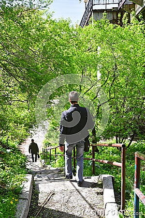 Vladivostok, Russia, May, 21, 2019. Man walking down the stairs from the upper station of the funicular to the lower station in sp Editorial Stock Photo