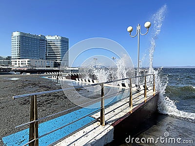 Vladivostok, Russia, October, 10, 2023. Waves on the Sports embankment against the background of the Barny apart-hotel Editorial Stock Photo