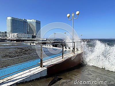 Vladivostok, Russia, October, 10, 2023. Waves on the Sports embankment against the background of Barny apart-hotel Editorial Stock Photo