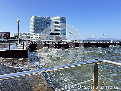 Vladivostok, Russia, October, 10, 2023. Waves on the Sports embankment against the background of the Barny apart-hotel Editorial Stock Photo