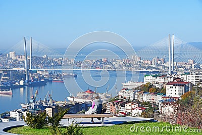 Vladivostok, Russia, October, 12, 2022. Young woman admires the city of Vladivostok from the observation deck in the Upland Park o Editorial Stock Photo