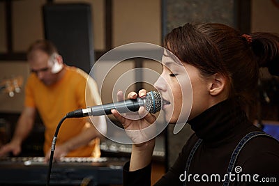 Vocalist girl is singing in studio. Stock Photo