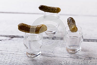 Vodka shots with pickled cucumber on bar counter Stock Photo