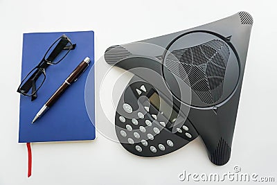 Voip IP conference phone with notebook and eyeglasses for taking minute of meeting in office Stock Photo