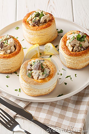 Vol au vent baked puff pastry with chicken, mushroom and cream closeup on the white wooden table. Vertical Stock Photo