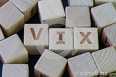 Volatility Index, known by its ticker symbol VIX concept, cube wooden block with alphabet combine the word VIX on black chalkboard Stock Photo