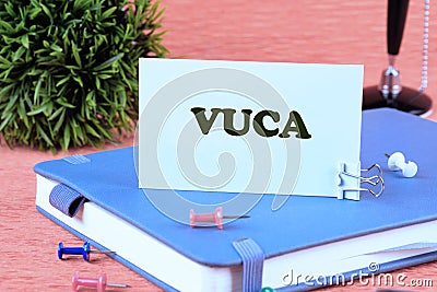 Volatility Uncertainty Complexity Ambiguity. VUCA text on a white business card standing on a business notebook Stock Photo