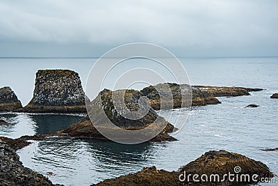 volcanic islets off the Icelandic coast, near the famous Gatklettur stone bridge Stock Photo