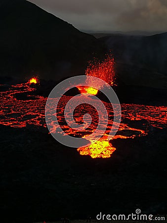 Volcano with lava pouring into the air from a crater Stock Photo