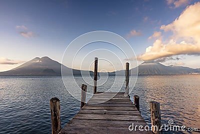 Volcanoes and dock on lake Atitlan at sunrise Stock Photo