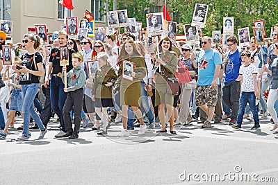 Soviet female soldiers in uniform with participants of the action `Immortal Regiment` walking along street on Victory day in V Editorial Stock Photo