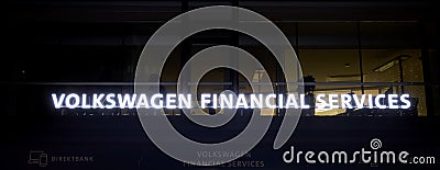 Volkswagen Financial Services illuminated billboard with the name of the financial institution in the pedestrian zone of Wolfsburg Editorial Stock Photo