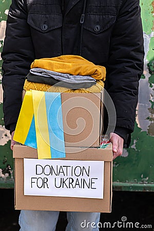 Volunteer carrying boxes with Humanitarian aid for Ukrainian refugees in street Stock Photo