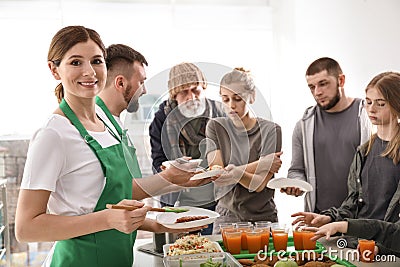 Volunteer with colleague giving food to poor people Stock Photo