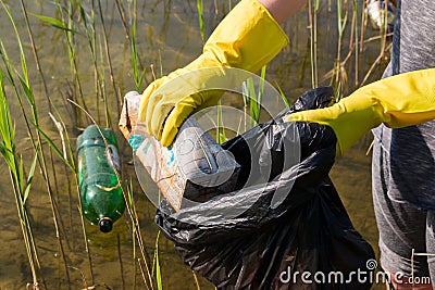 Volunteer collecting garbage from the lake Stock Photo