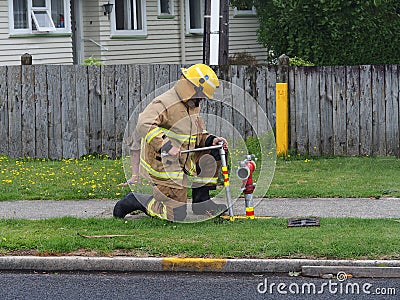 Volunteer first responder connecting fire hose to water main Editorial Stock Photo