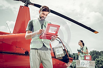 Volunteer opening first aid box and checking everything inside Stock Photo