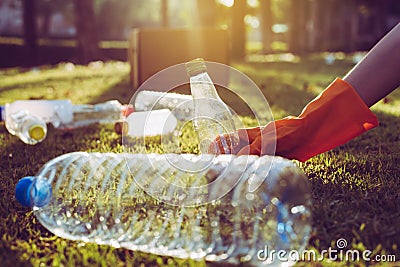 Volunteer woman hands holding and keep trash on green grass,Good conscious mind,Dispose recycle and waste management concept Stock Photo
