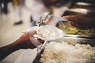 Volunteers are donating free charity food to homeless beggars: the concept of food needs in society Stock Photo