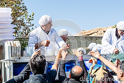 Volunteers giving charity drinks to the local people on ashura festival in Shiraz City, Iran Editorial Stock Photo