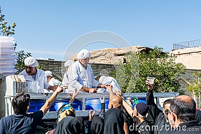 Volunteers giving charity drinks to the local people on ashura festival in Shiraz City, Iran Editorial Stock Photo