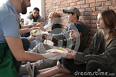 Volunteers giving food to poor people Stock Photo