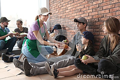 Volunteers giving food to poor people Stock Photo