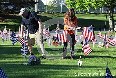 Volunteers placing an American Flag on the grave of a Military Veteran for Memorial Day Editorial Stock Photo