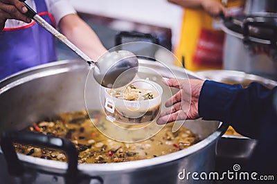 Volunteers are sharing food to needy hungry people Stock Photo