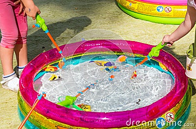 Children catch toy fish in the children`s pool. Editorial Stock Photo