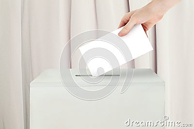 Vote concept. Voter hand holding ballot paper for election vote on polling station Stock Photo