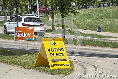 A Voting Place Elections Alberta sign on a busy street. Yellow double sided floor stand Editorial Stock Photo