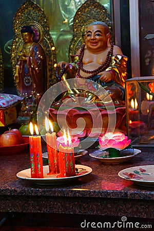 Votive candles and incense, with Buddha Stock Photo