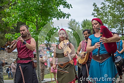 View of an outdoor celtic music concert, with musicians dressed in medieval costumes and playing medieval instruments, in medieval Editorial Stock Photo