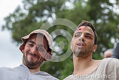 View of two young actors dressed in medieval clothes on medieval market, blurred background Editorial Stock Photo