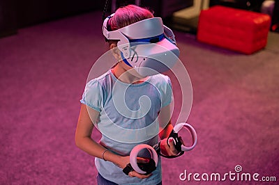Vr game and virtual reality. kid girl gamer eight years old fun playing on futuristic simulation video game in 3d glasses and joys Stock Photo