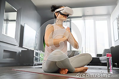 VR, meditation and fitness with a woman using a headset to access the metaverse in her home for health. Virtual reality Stock Photo