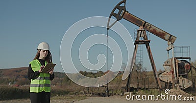 Vrouw-ingenieur in harde hoed gebruikt een tabletcomputer Industriële Petroleum Engineer vrouw Werkt aan Digital Tablet Kijk uit stock footage Vrouw-ingenieur in harde hoed gebruikt een tabletcomputer Industriële Petroleum Engineer vrouw Werkt aan Digital Tablet Kijk uit stock footage