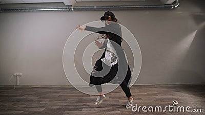 Vrouwelijke danser in wit overhemd, zwarte broeken en zwart GLB die moderne jazz-lafbek tonen die in klaslokaal met spiegels dans stock footage Vrouwelijke danser in wit overhemd, zwarte broeken en zwart GLB die moderne jazz-lafbek tonen die in klaslokaal met spiegels dans stock footage