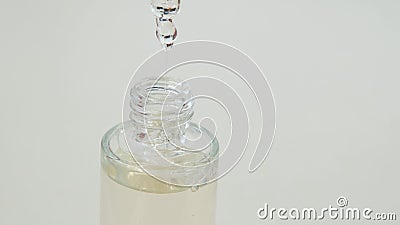 Vrouwen houden een glazen flesje vast met een steriel, essentieel collageenserum met een druppelaar op een wazige achtergrond dich stock footage Vrouwen houden een glazen flesje vast met een steriel, essentieel collageenserum met een druppelaar op een wazige achtergrond dich stock footage