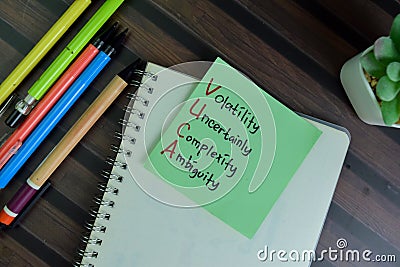 VUCA - Volatility Uncertainly Complexity Ambiguity write on sticky notes isolated on Wooden Table Stock Photo