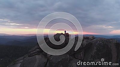 Vue aérienne de l'homme seul se tenant sur une falaise et appréciant le coucher du soleil banque de vidéos Vue aérienne de l'homme seul se tenant sur une falaise et appréciant le coucher du soleil banque de vidéos