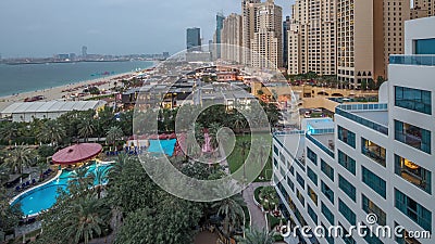 Vue a?rienne de la plage et des touristes marchant dans JBR avec le jour de gratte-ciel au timelapse de nuit ? Duba?, EAU banque de vidéos Vue a?rienne de la plage et des touristes marchant dans JBR avec le jour de gratte-ciel au timelapse de nuit ? Duba?, EAU banque de vidéos