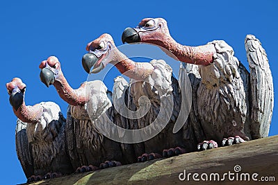 Sculpture of nasty vultures sitting on a plank and watch Editorial Stock Photo