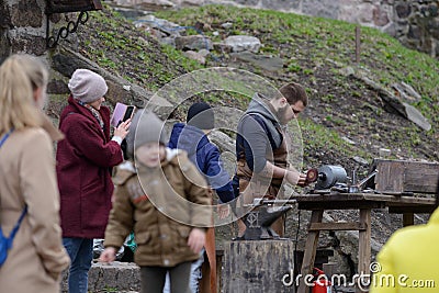 Vyborg, Russia, May 1, 2021-festival of medieval masters. A man dressed in the garb of medieval European blacksmith shows a master Editorial Stock Photo